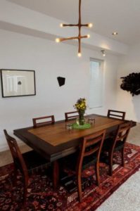 The dining table in the home has a Peter Zubiate light fixture hanging over it.